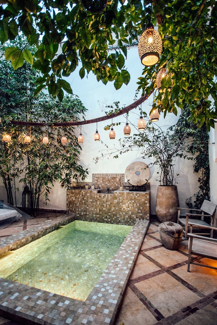 Traditional oriental hammam pool on exotic resort spa terrace decorated with lush plants and stylish lanterns